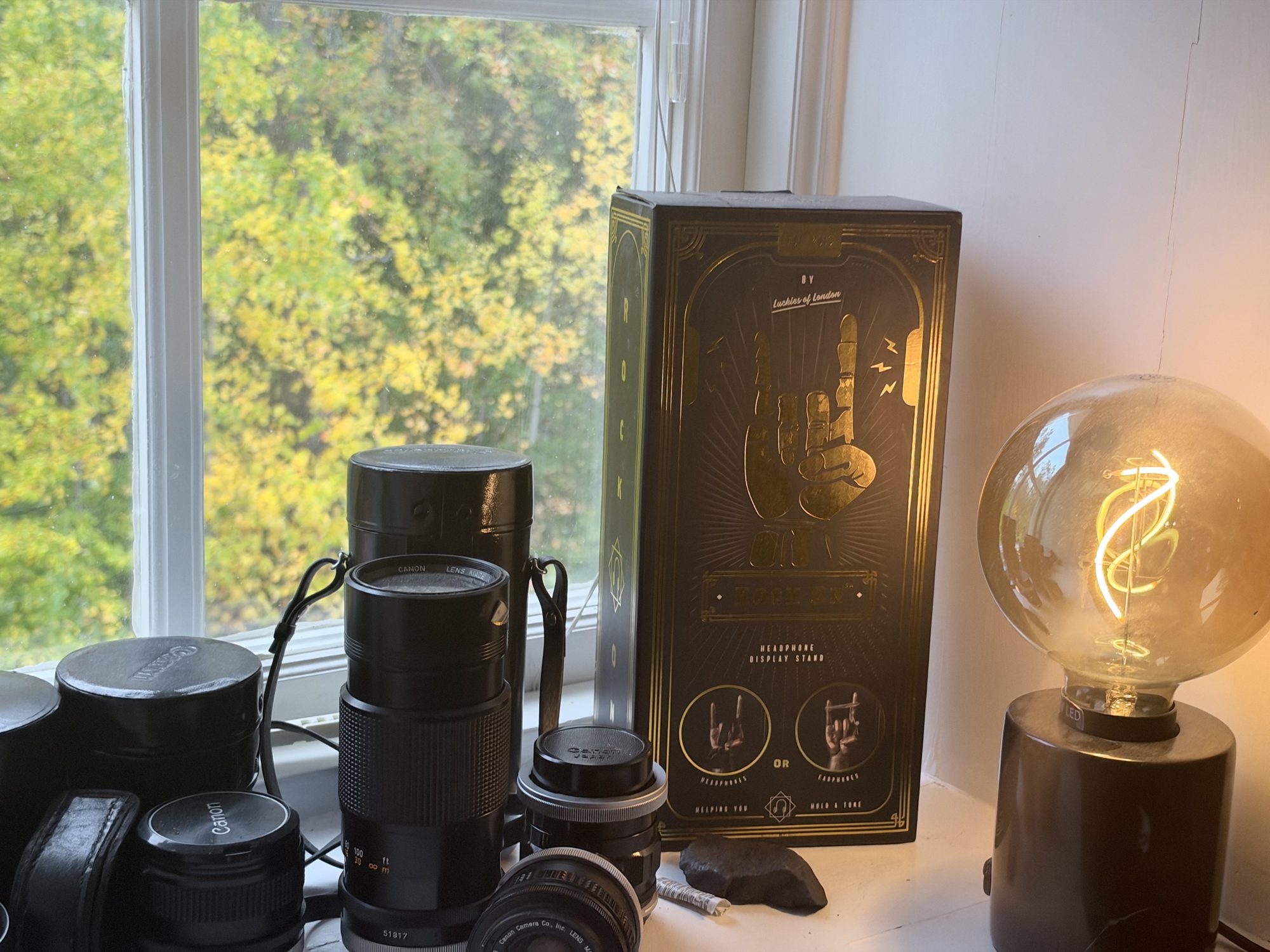 Kameraobjektiv och glödlampa i fönstret.