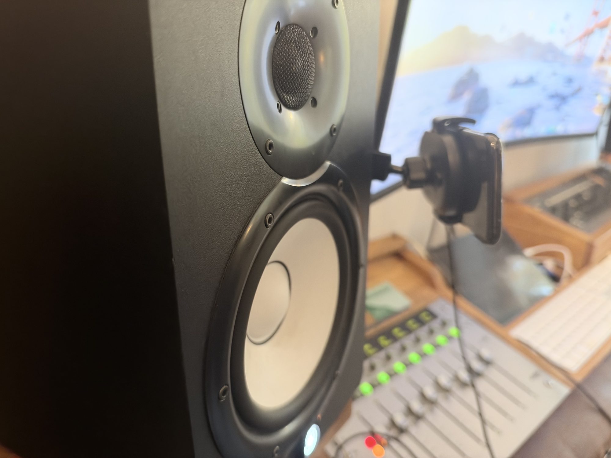 Studiomonitor i närbild framför mixerbordet.